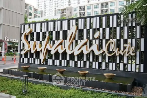 Modern building entrance with stylish Supalai signage and water feature.