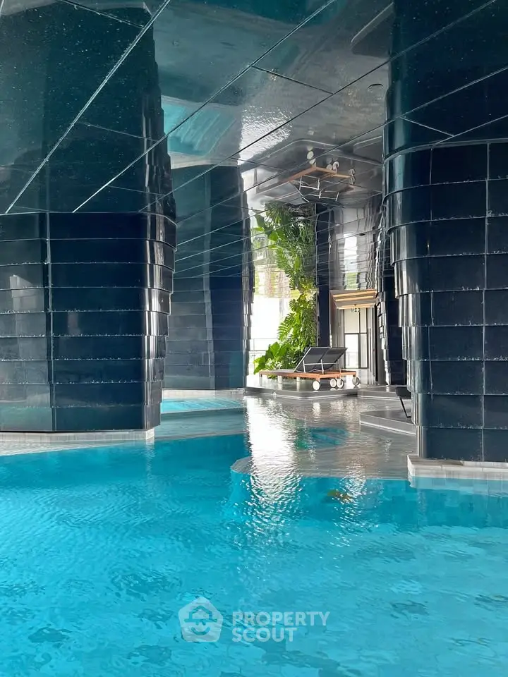 Luxurious indoor pool with modern architectural design and lush greenery, perfect for relaxation and leisure.