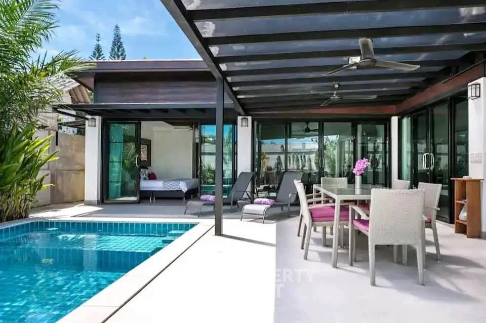 Luxurious outdoor patio with pool and modern furniture in a tropical villa setting.