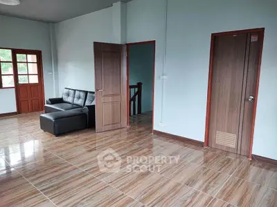 Spacious living room with modern tile flooring and stylish wooden doors