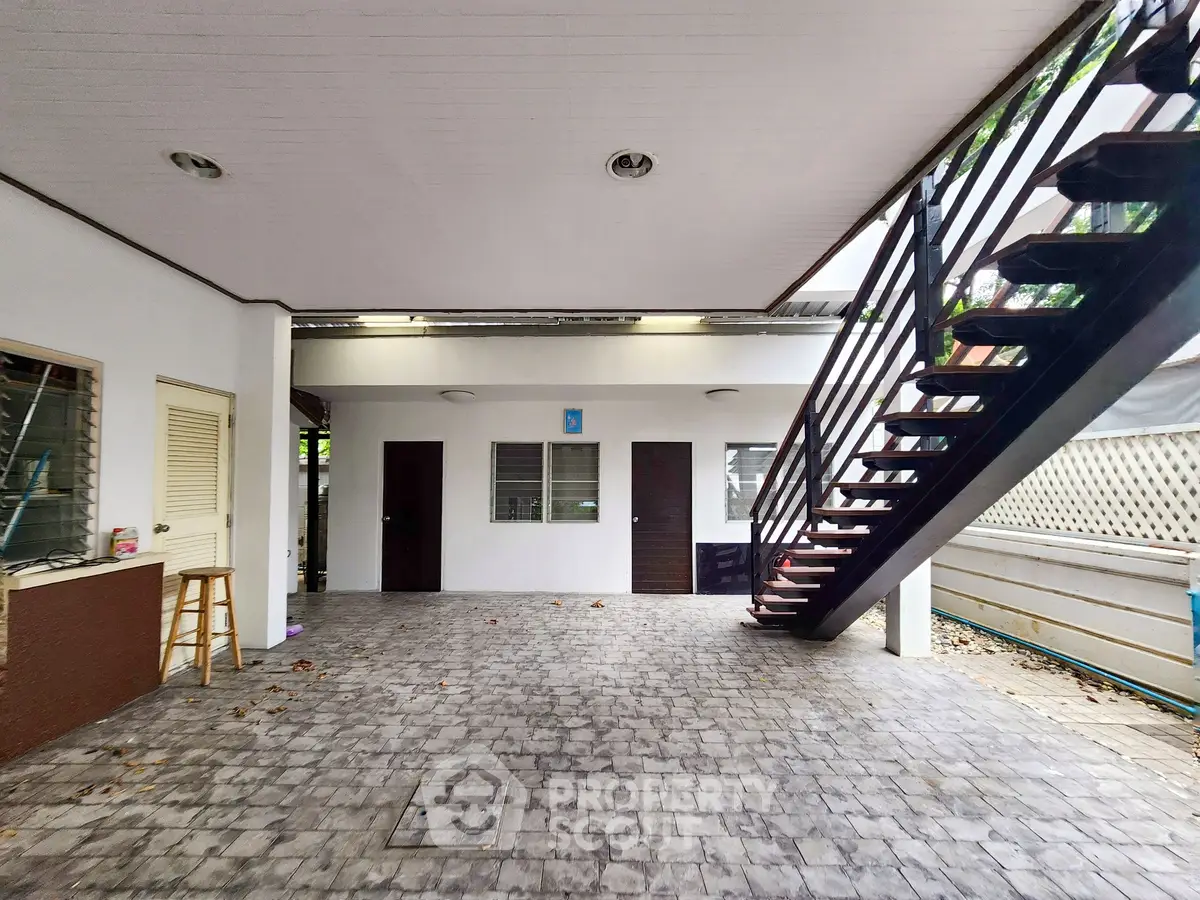 Spacious outdoor area with staircase and tiled flooring, ideal for versatile use.