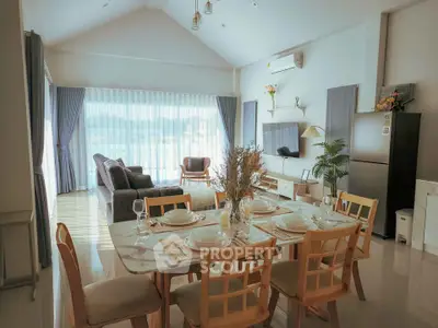 Spacious open-plan living and dining area with modern decor and large windows.