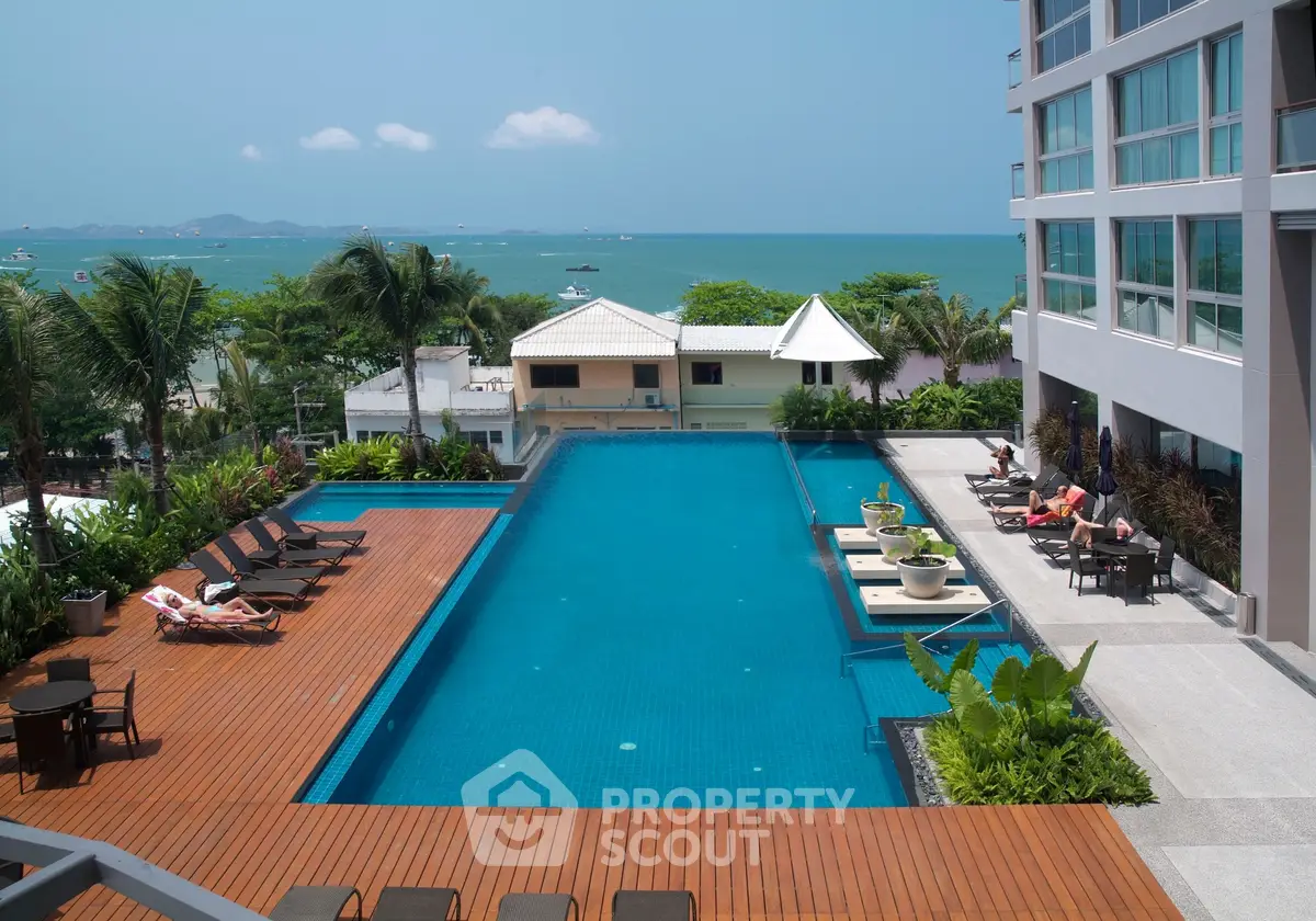 Luxurious beachfront condominium with stunning pool and ocean view, perfect for relaxation and leisure.