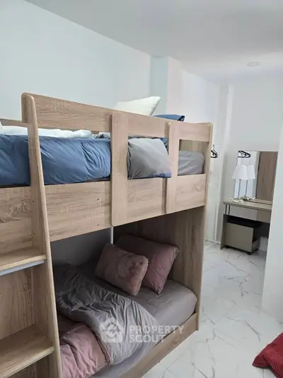 Modern bedroom with stylish bunk beds and sleek white flooring.