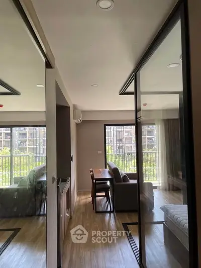 Modern living room with large windows and stylish furniture, offering a bright and inviting atmosphere.