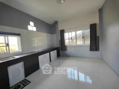 Spacious kitchen with sleek tile flooring and ample natural light