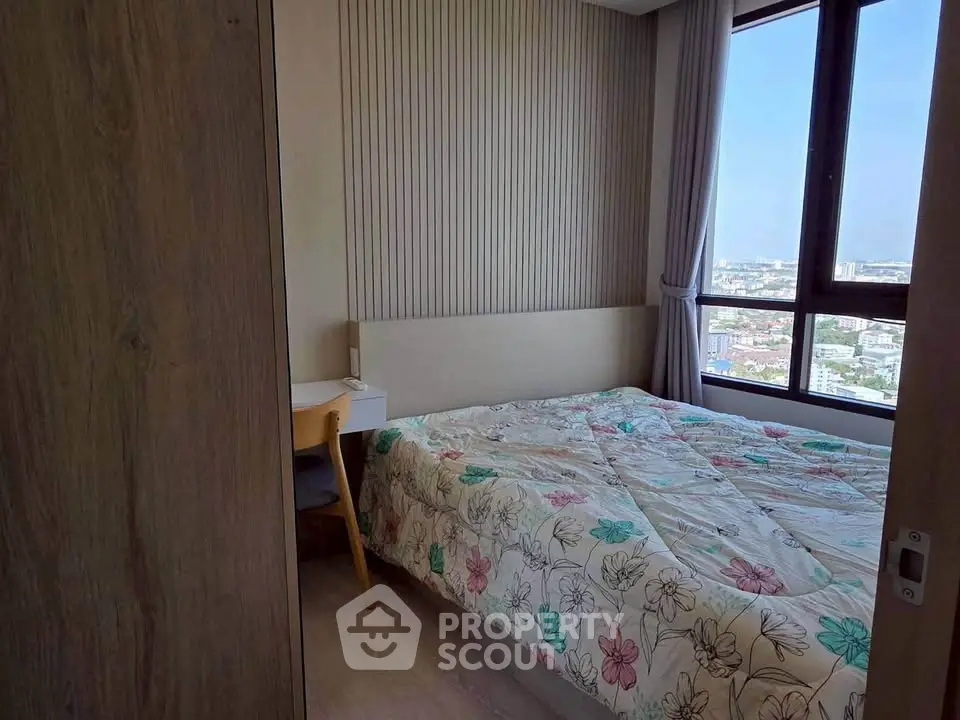 Cozy bedroom with city view and floral bedding in modern apartment