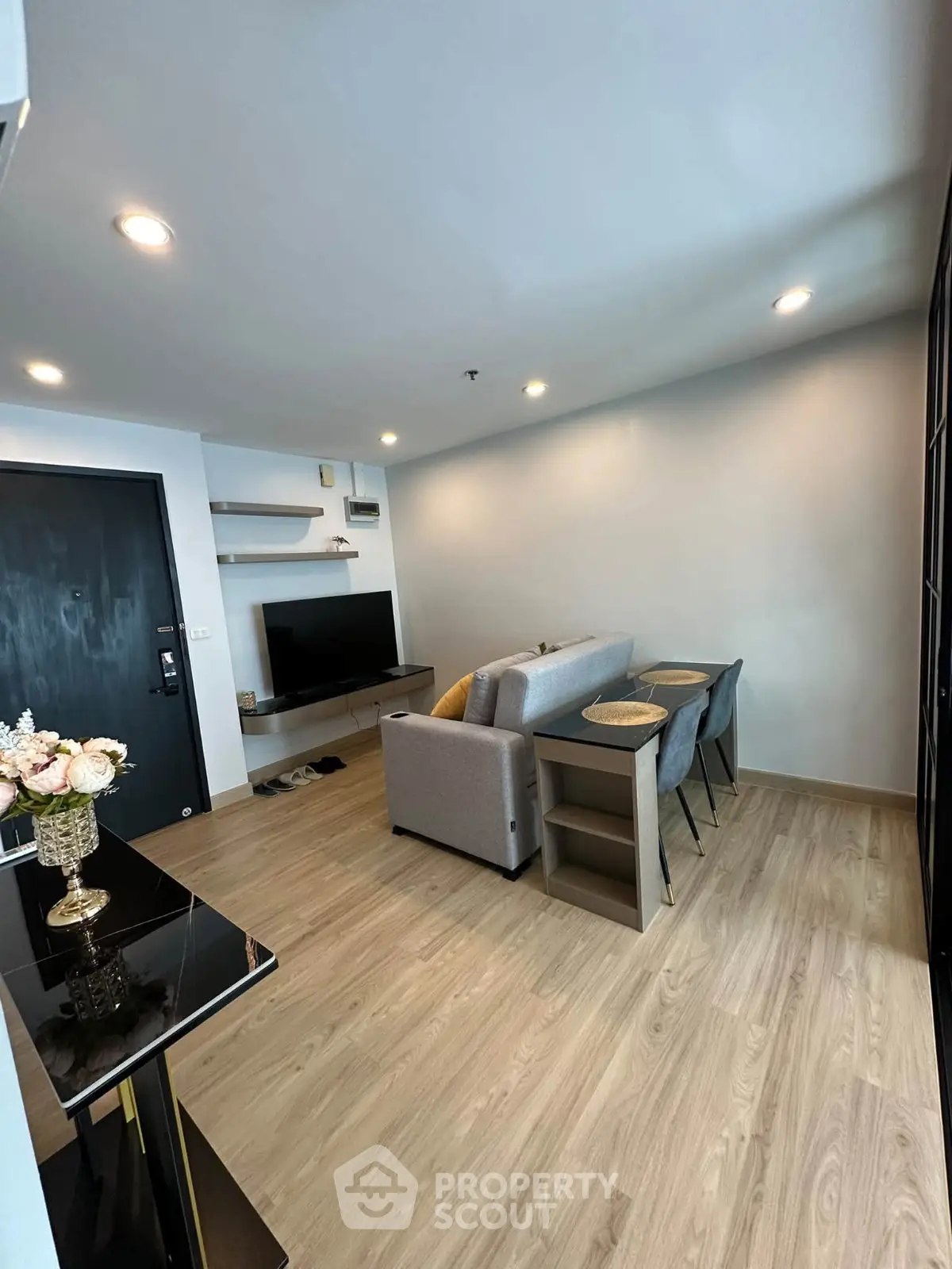 Modern living room with stylish decor and open layout, featuring a cozy sofa and elegant dining area.