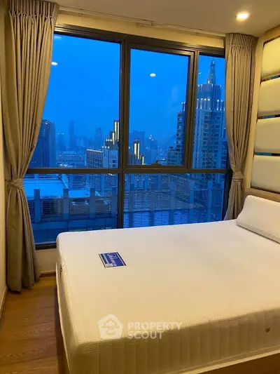 Luxurious bedroom with stunning city view and large windows in modern high-rise apartment.