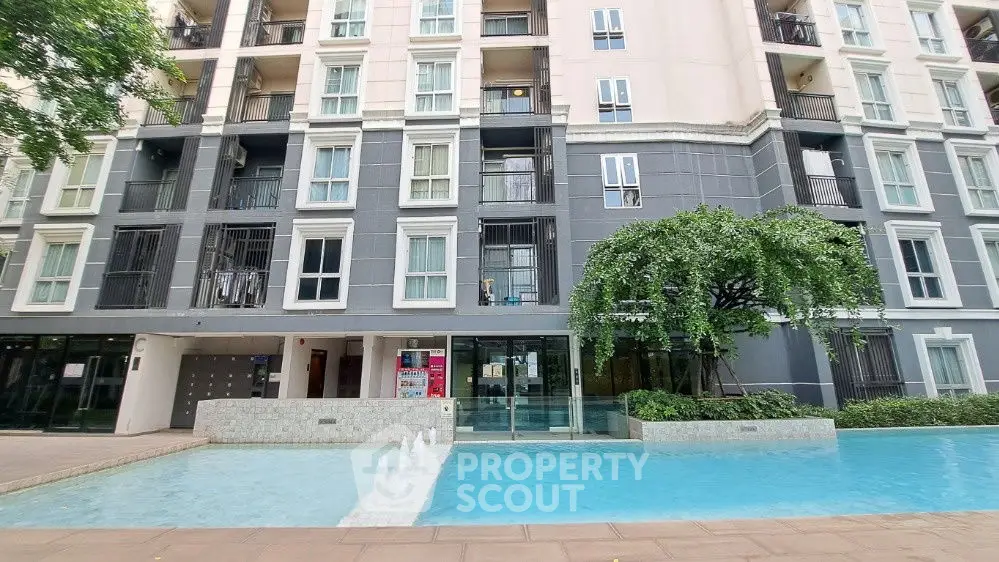 Modern apartment building with pool and lush greenery, perfect for urban living.