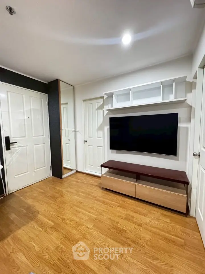 Modern living room with sleek TV setup and wooden flooring