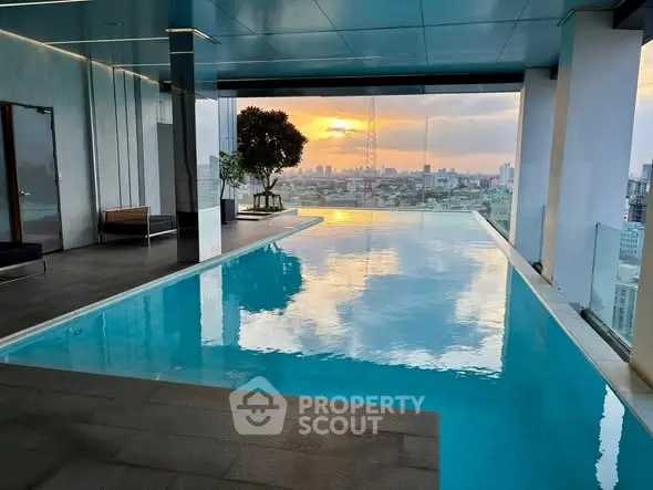 Luxurious rooftop pool with stunning city skyline view at sunset.
