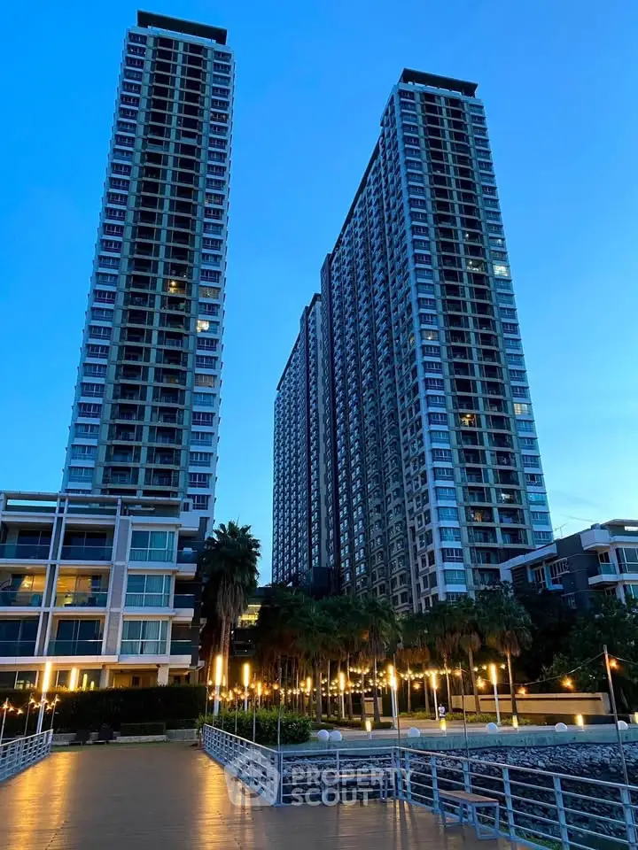 Stunning high-rise residential towers with modern architecture and lush landscaping at dusk.