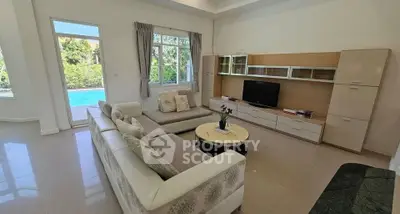 Spacious living room with modern furniture and pool view, perfect for relaxation and entertainment.