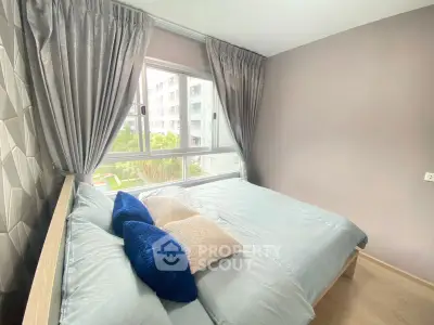 Modern bedroom with large window and stylish decor in a contemporary apartment.
