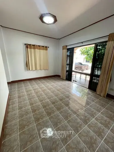 Spacious unfurnished room with tiled flooring and large windows for natural light.