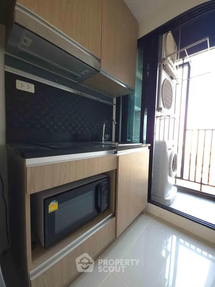 Modern kitchen with sleek appliances and balcony view