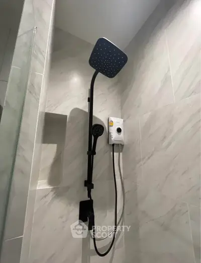 Modern bathroom shower with sleek design and marble tiles, featuring a rainfall showerhead and water heater.