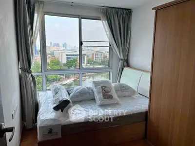 Bright bedroom with large windows offering stunning city views, featuring a cozy bed and modern decor.