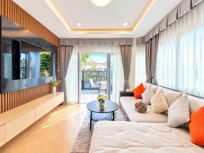 Luxurious living room with modern decor and large windows opening to a scenic balcony view.