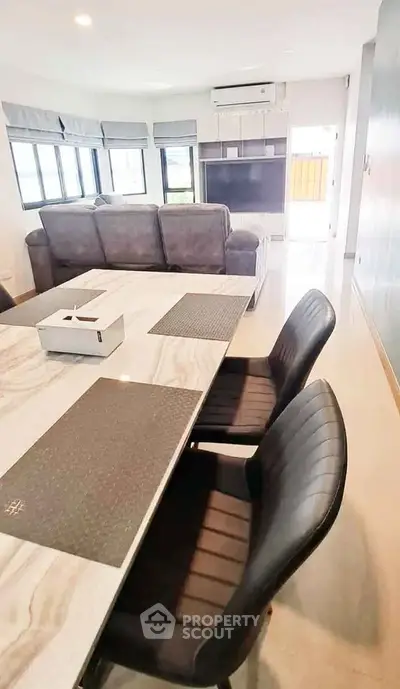 Spacious modern living room with elegant dining area and large windows for natural light.
