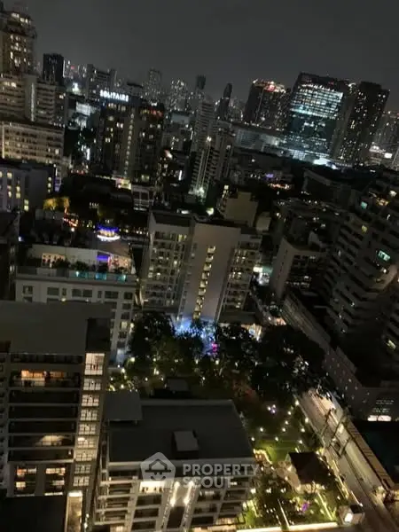 Stunning night cityscape view from high-rise apartment overlooking vibrant urban skyline.