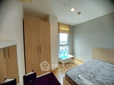 Cozy bedroom with wooden furniture and city view, perfect for urban living.