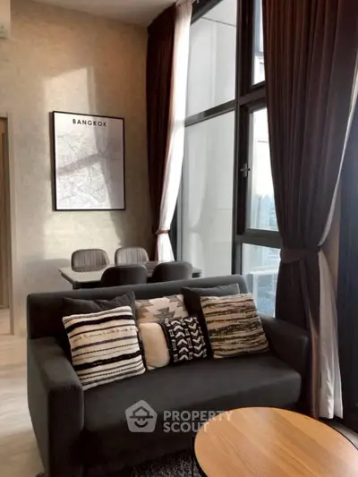 Modern living room with stylish decor and city view in Bangkok apartment.