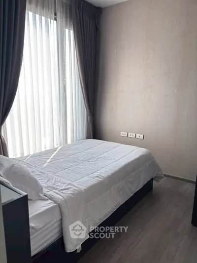 Cozy bedroom with natural light and modern decor, perfect for relaxation and comfort.