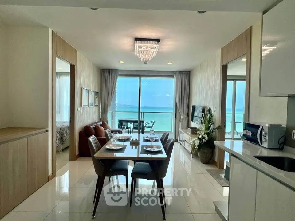 Stunning beachfront condo with open living area and ocean view balcony, perfect for luxury living.