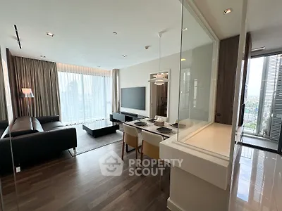 Spacious modern living room with dining area and large windows offering city views.