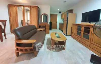 Spacious living room with wooden furniture and modern amenities in a cozy apartment.