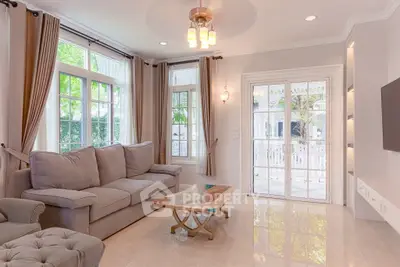 Elegant living room with large windows and stylish furniture, perfect for relaxation and entertaining.