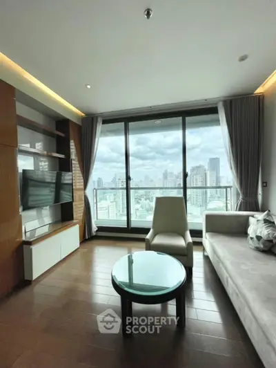 Modern living room with city view, featuring sleek furniture and large windows for natural light.