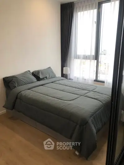 Cozy bedroom with large window and modern decor in a stylish apartment.