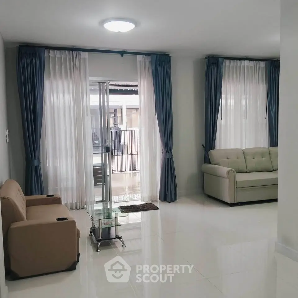 Spacious living room with elegant curtains and cozy sofas, perfect for relaxation and entertaining guests.