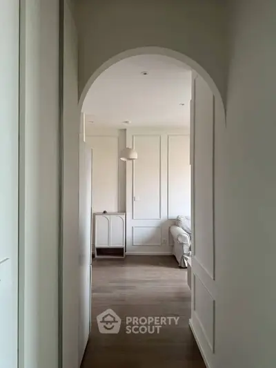 Elegant hallway leading to a cozy living room with stylish decor and soft lighting.