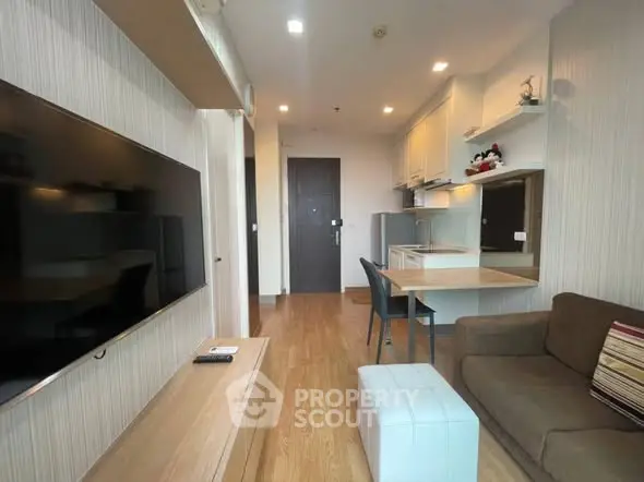 Modern living room with sleek furniture and large TV, perfect for relaxation and entertainment.