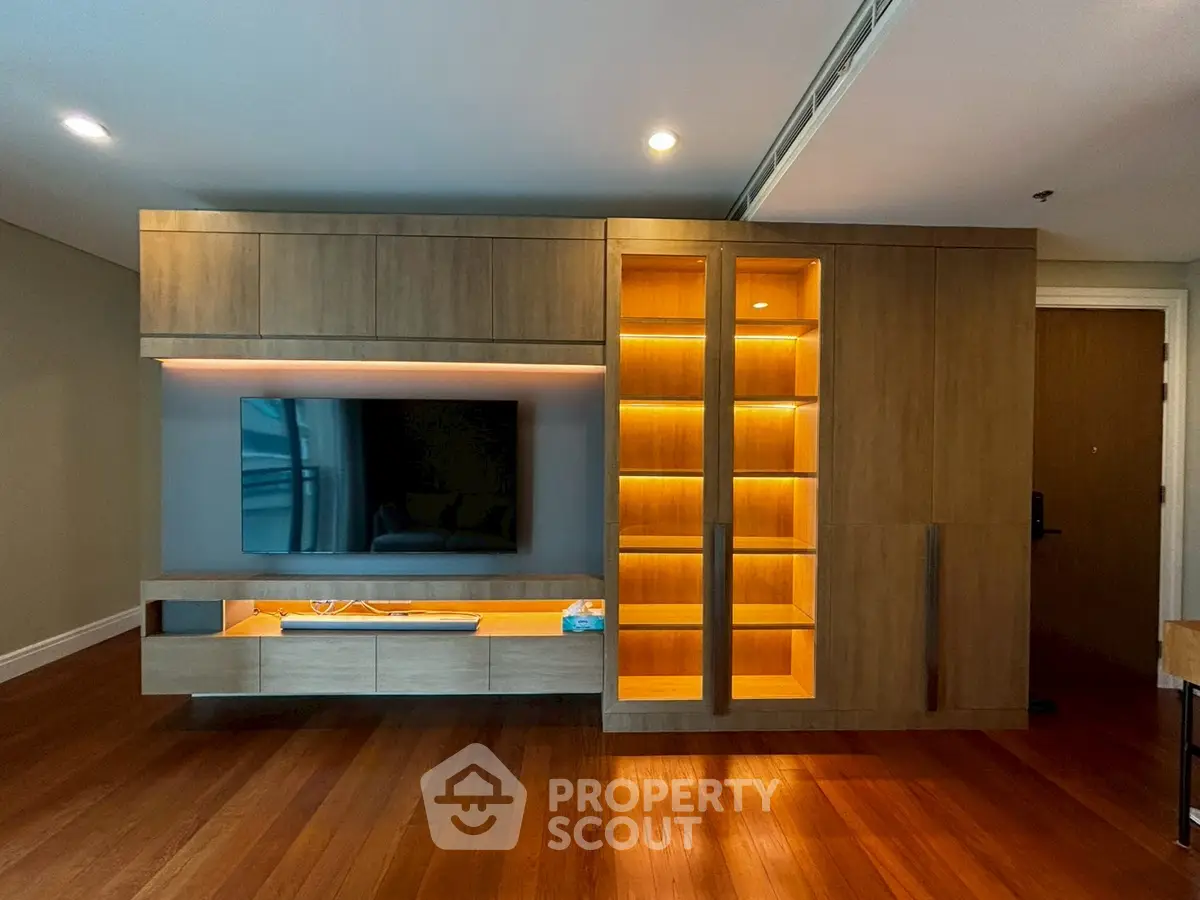 Modern living room with stylish wooden entertainment unit and ambient lighting