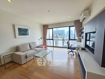 Spacious modern living room with city view, featuring sleek furniture and large windows.