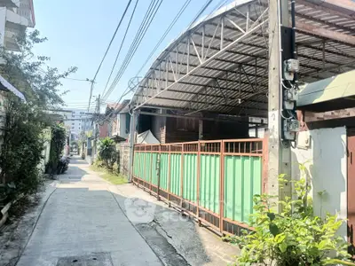 Charming urban alley with gated property and metal roof structure