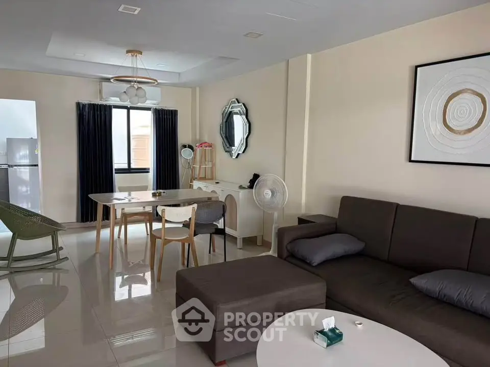 Modern living room with stylish furniture and elegant decor, featuring a cozy seating area and dining space.