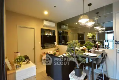 Modern living room with stylish decor and mirrored wall, featuring cozy seating and elegant lighting.