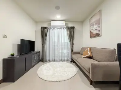 Modern living room with cozy sofa, TV, and elegant decor.
