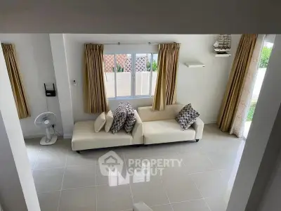 Spacious living room with modern decor and large windows for natural light.