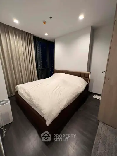 Modern bedroom with cozy bed and elegant curtains in a stylish apartment.