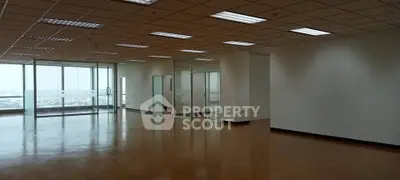 Spacious office space with large windows and wooden flooring, ideal for businesses seeking a bright and open environment.