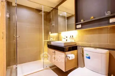 Modern bathroom with glass shower and sleek fixtures in luxury apartment.