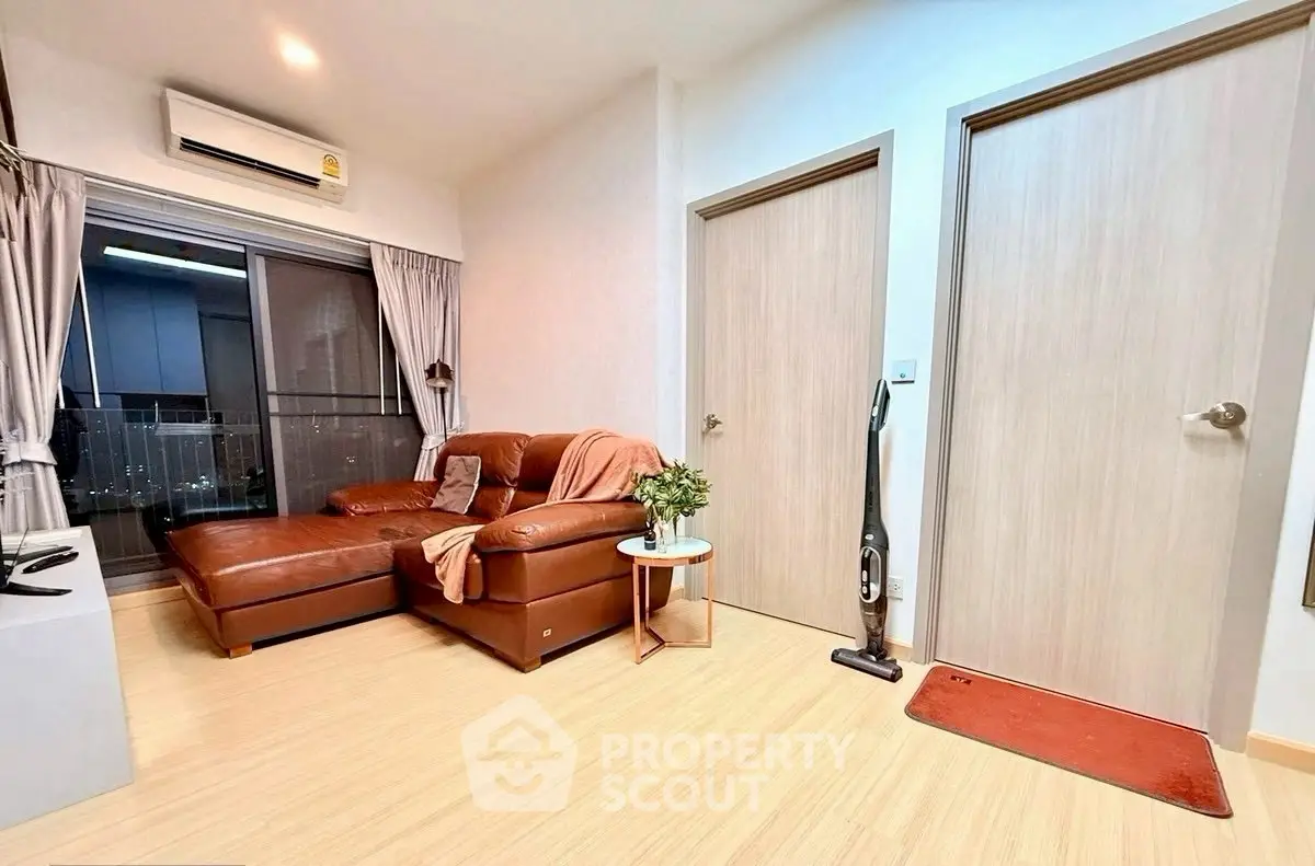 Modern living room with leather sofa and city view, featuring sleek design and cozy ambiance.