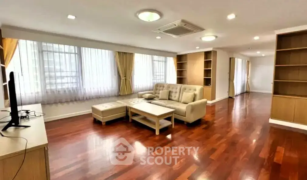 Spacious living room with hardwood floors and elegant furniture in a modern apartment.